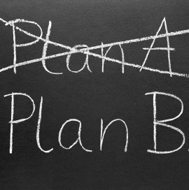 Crossing out Plan A and writing Plan B on a blackboard.